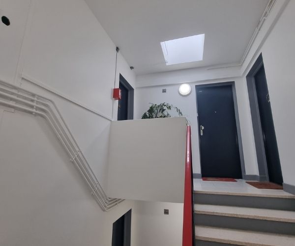 Couloir d’immeuble rénové avec peinture claire et finitions propres