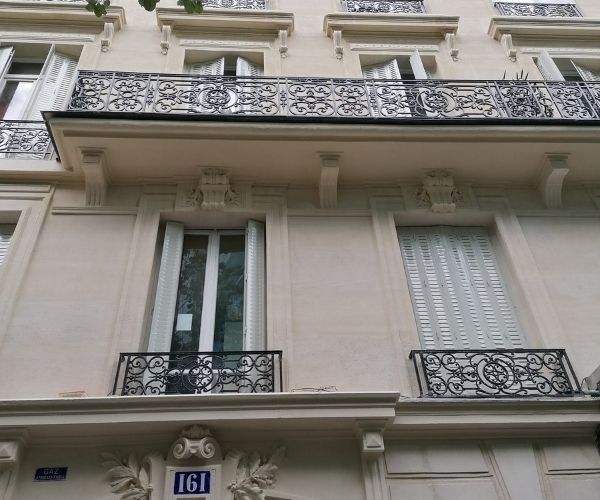 Détail de façade haussmannienne avec balcons et garde-corps rénovés à Paris 16