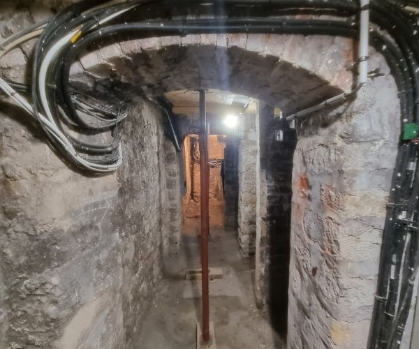 Couloir de caves avec étaiement de sécurité dans immeuble ancien