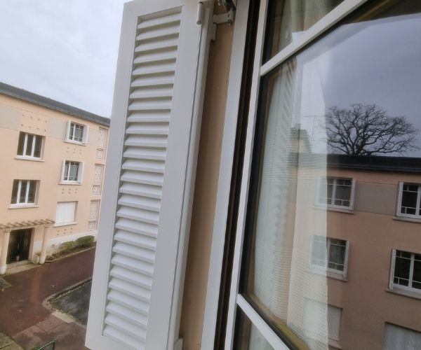 Détail de volet battant blanc et fenêtre rénovée dans une résidence au Plessis-Robinson