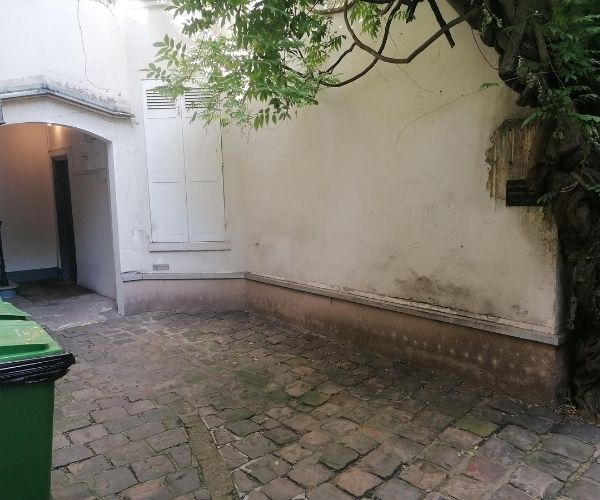 Passage en cour intérieure avec murs anciens à Paris