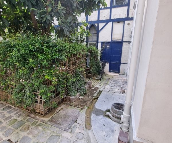 Cour intérieure pavée avec végétation existante à Paris