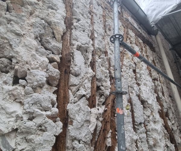 Mur en pierre apparente dans une cour intérieure à Paris